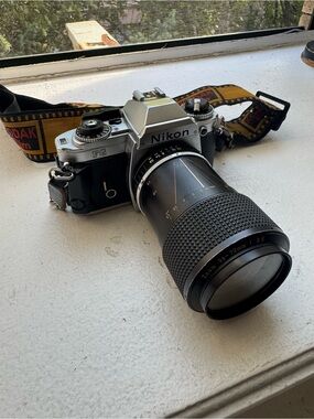 Nikon FG 35mm Film Camera with Black Zoom Lens and Kodak Film Strap